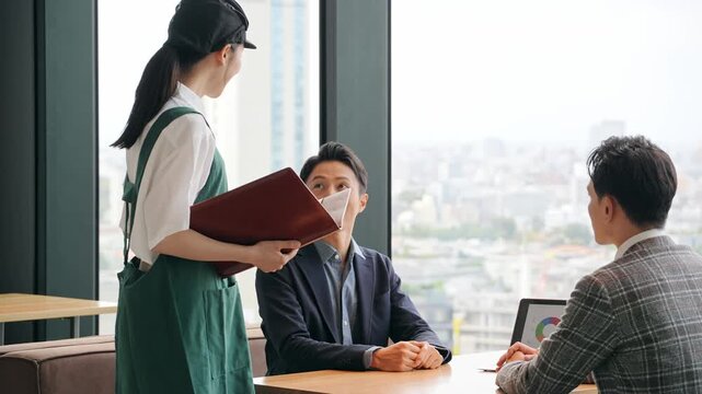 店内で接客する飲食店店員