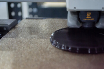 3D printer close up. Working 3D printer in process of printing object from molten black plastic. 3D printer creating model by flowing liquid plastic from extruder of printer. 3D printing technology