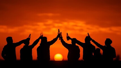 Silhouettes of friends toasting drinks against a vibrant sunset
