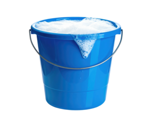 A blue bucket overflows with frothy white bubbles, handle arched, dark background