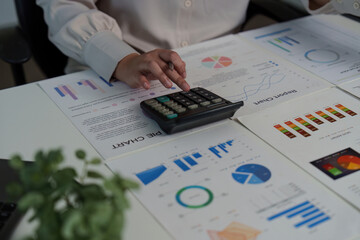 Financial Analysis. Professional analyzing data with calculator and charts on desk.