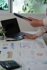 Digital Analysis. Professional using tablet and laptop for financial data review.