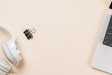 Laptop and stationery on beige workspace, top view with copy space