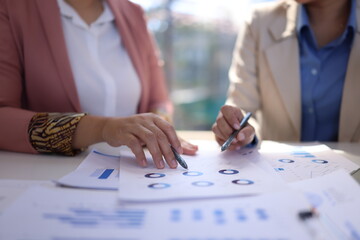 Two businesswoman working with business financial graph data and marketing plan at desk in office, Business concept.