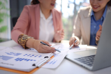 Two businesswoman working with business financial graph data and marketing plan at desk in office, Business concept.
