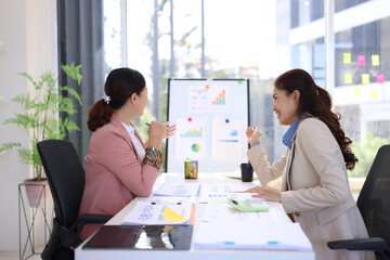 Obraz premium Two businesswoman working with business financial graph data and marketing plan at desk in office, Business concept.