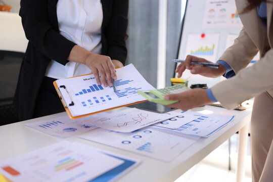 Business person hands working with business financial graph data and marketing plan at desk in office, Business people meeting explaining and business concept. - Powered by Adobe
