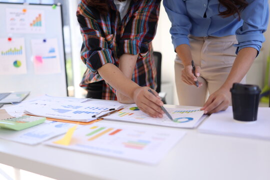 Business person hands working with business financial graph data and marketing plan at desk in office, Business people meeting explaining and business concept. - Powered by Adobe