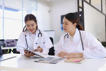 Two medical doctors working on laptop with tablet and a CT scan in clinic office, Body x-ray film, Medical technology and Healthcare concept. 