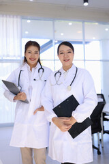 Two medical doctors woman checking the patient papers in  hospital, Medical technology and Healthcare concept. 