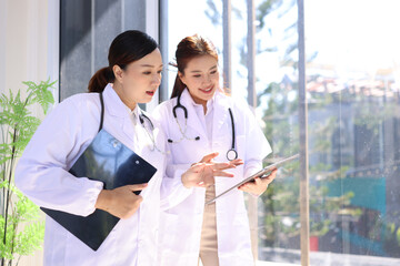 Two medical doctors woman checking the patient papers in  hospital, Medical technology and Healthcare concept. 