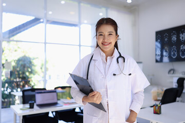 portrait of a smiling female doctor standing with clipboard at hospital , medical and health care.
