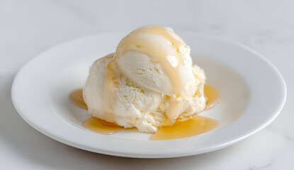 Delicious vanilla ice cream drizzled with rich caramel sauce on a white plate.