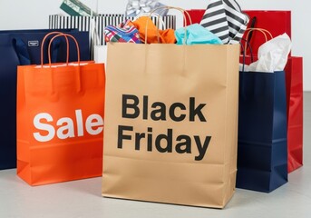 Brown Black Friday shopping bag with orange sale bag and other bags image
