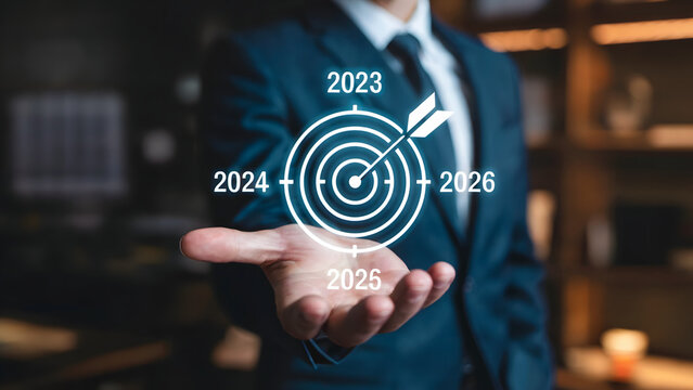 A businessman presenting a target with an arrow and dates from two thousand twenty three to twenty six