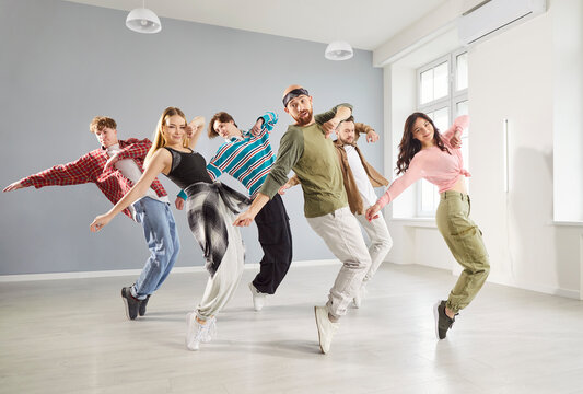 Group of dancers dancing together under music in dance studio during lesson, practicing contemporary choreography, fostering team spirit in a space dedicated to training and collaborative dance. - Powered by Adobe