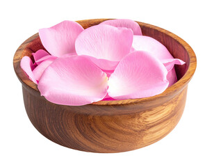 Pink rose petals overflowing a textured wooden bowl against a stark black backdrop