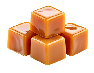 Glossy, golden-brown caramel cubes stacked atop one another, against a black background