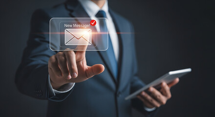 Businessman touching a digital notification icon for email on a dark background
