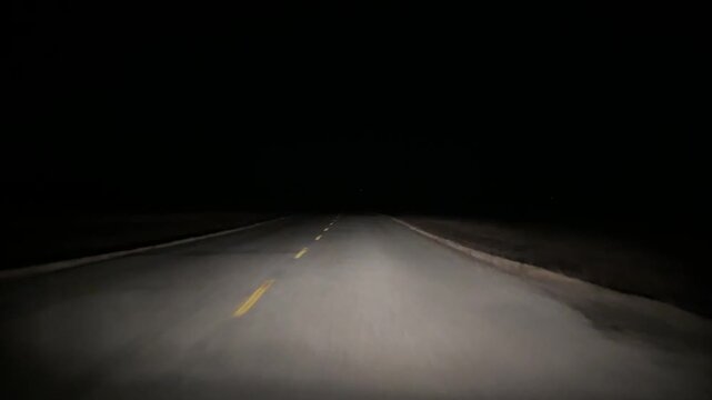 Windshield perspective of nighttime driving with lower visibility in rural Alberta Canada.