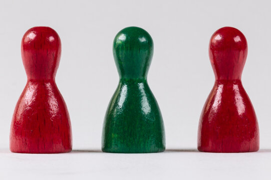 three wooden game pieces in green and red