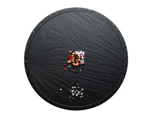 Round, textured black slate tray holding a small pile of colored salts and spices