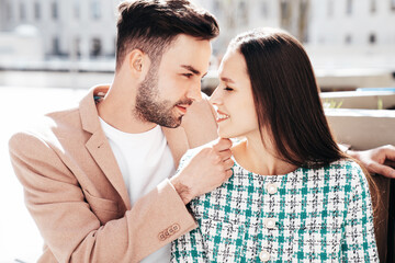 Beautiful fashion woman and her handsome elegant boyfriend in beige suit. Sexy brunette model in summer clothes. Fashionable smiling couple posing in street Europe. Brutal man and female outdoors
