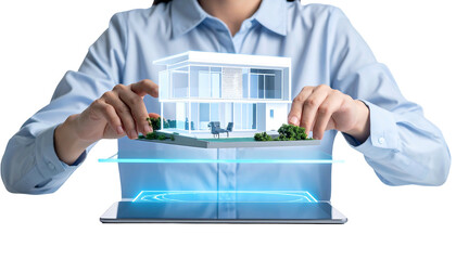 A person holds a digital architectural model above a tablet. The model depicts a modern house with greenery