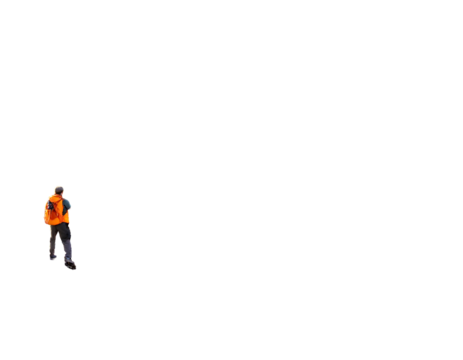 A person in a safety vest stands at the edge of a vast dark expanse, possibly a construction site