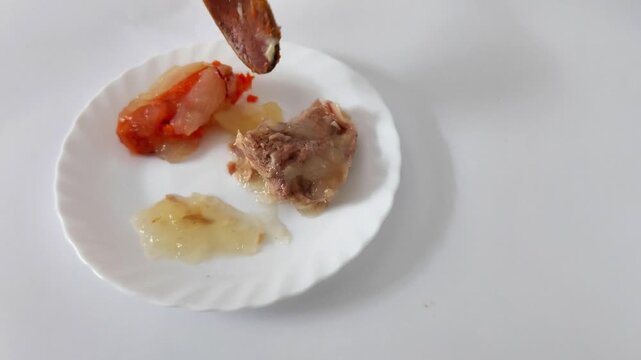 Carrot, braised meat, and translucent gelatin plated on white porcelain-each element arranged for maximum texture contrast and visual bite in this tactile food sampler