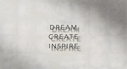 Inspirational wall art displaying the motivational words 'Dream', 'Create', and 'Inspire' with shadows cast on a light gray background