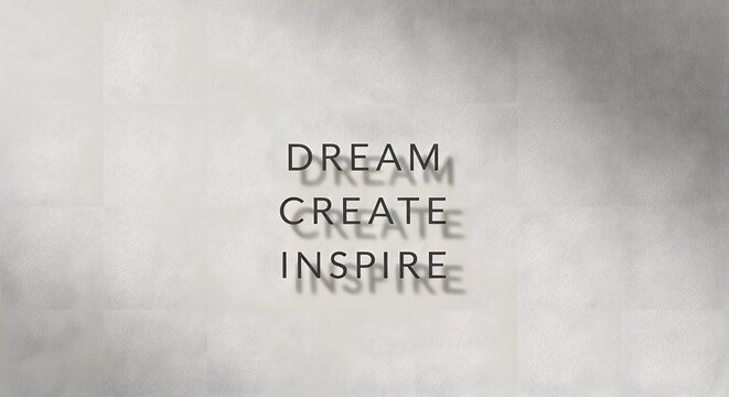 Inspirational wall art displaying the motivational words 'Dream', 'Create', and 'Inspire' with shadows cast on a light gray background