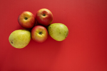 Fruits on a red background: pears, apples