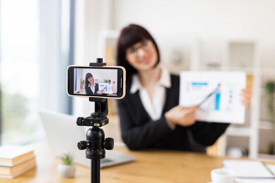 Caucasian woman recording business presentation, sharing strategies and data analysis from laptop setup - Powered by Adobe