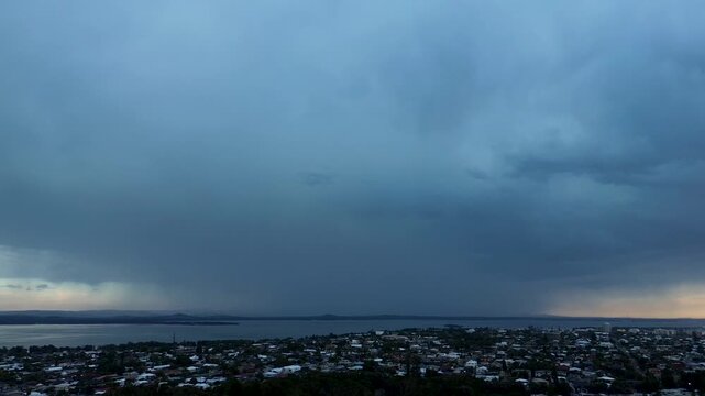 Drone aerial landscape of lightning strikes and zaps from looming storm clouds over suburban town and rural housing on a rainy morning in Long Jetty Central Coast Australia weather nature environment