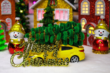 Among the houses of the Christmas village there are two snowmen with a car between them