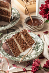 Slice of chocolate layered cake on rustic plate for birthday celebration with candles