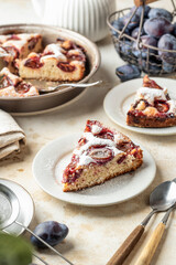 Homemade The New York Times plum cake. Slice of autumn fruit pie in a plate on beige textured background. Home cooking, recipe