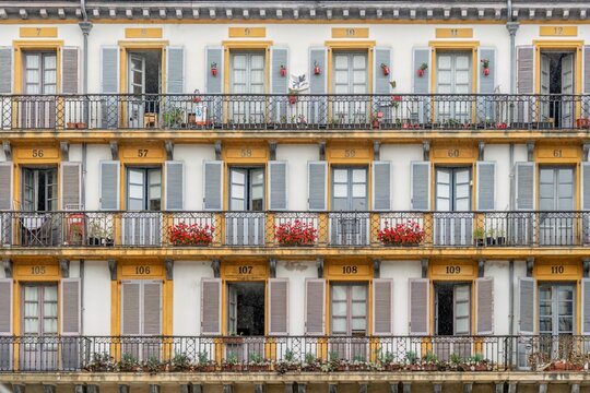 Traditional Apartment Building Facade with Numbered Doors and Flower Balconies
