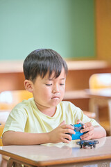 教室でドローンを操作する小学生の男の子