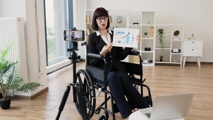 Caucasian woman in professional office showing financial chart during remote video blogging session. - Powered by Adobe