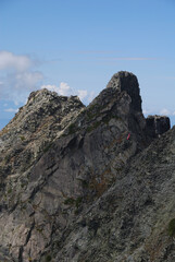 The cliffs of the eastern ridge of the Gendarme seen from the summit of Mt. Okuhotakadake (Trekking in Kamikochi in autumn) / 奥穂高岳山頂前から眺めるジャンダルムの東稜の断崖(秋の上高地をトレッキングする)
