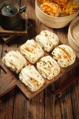 Handmade Asian Steamed Rolls with Savory Filling on Wooden Board - Traditional Chinese Dim Sum