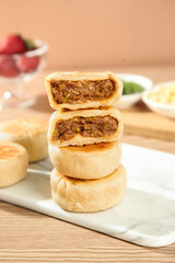 Chinese beef-filled pastries stacked on plate with fresh ingredients, traditional Asian savory snacks and dim sum cuisine