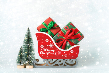 Red christmas sleigh with Christmas gifts and christmas trees. Christmas concept background