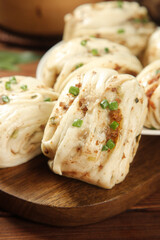 Handmade Steamed Buns with Scallion Garnish on Wooden Board - Traditional Asian Cuisine