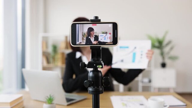Caucasian woman recording business presentation, sharing strategies and data analysis from laptop setup - Powered by Adobe
