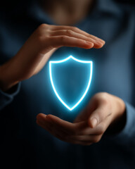hands protecting an illuminated shield symbol,  signifying protection and security in business