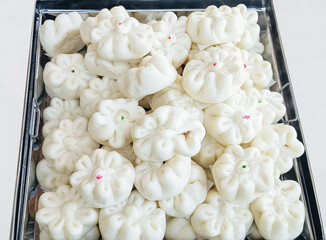 steamed Chinese buns in tray, traditional Asian dim sum food photography, arranged in metal serving tray, culinary packaging, street food promotions, dim sum advertisement isolated on white background