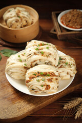 Handmade Chinese Pork Buns with Scallions and Bamboo Steamer on Wooden Table